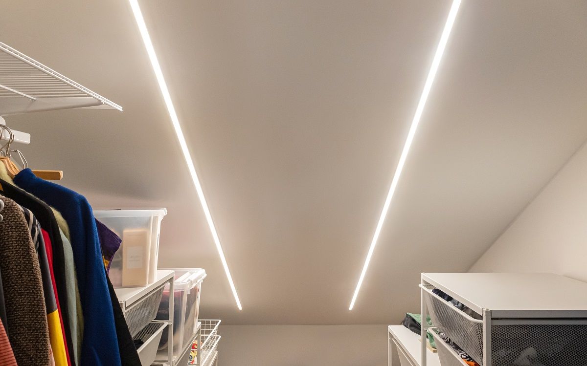 Il soffitto ripido dell'armadio è stato utilizzato per l'illuminazione a LED. La striscia LED nel profilo a incasso si armonizza bene con la superficie inclinata.